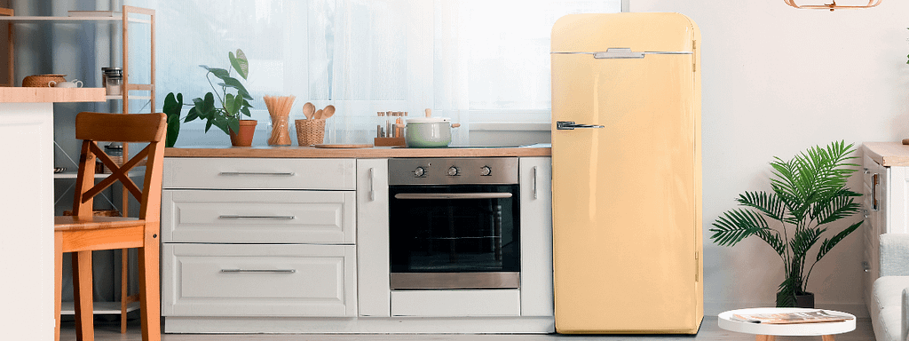 A build-in oven next to a yellow retro fridge freezer