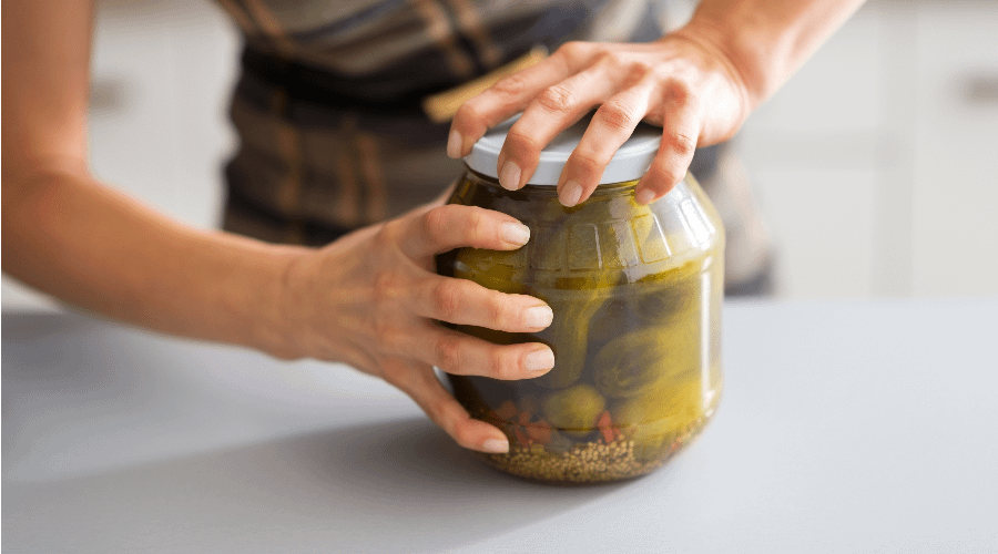 Person about to open a jar of pickles