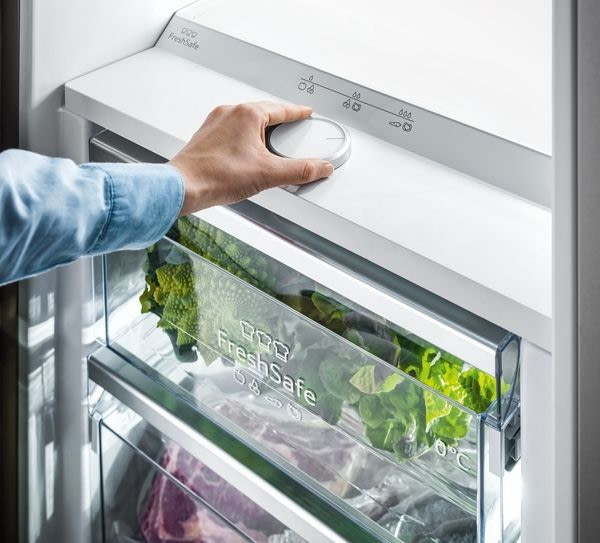 Neff FreshSafe Feature - person turning a temperature dial in their fridge for optimal vegetable humidity