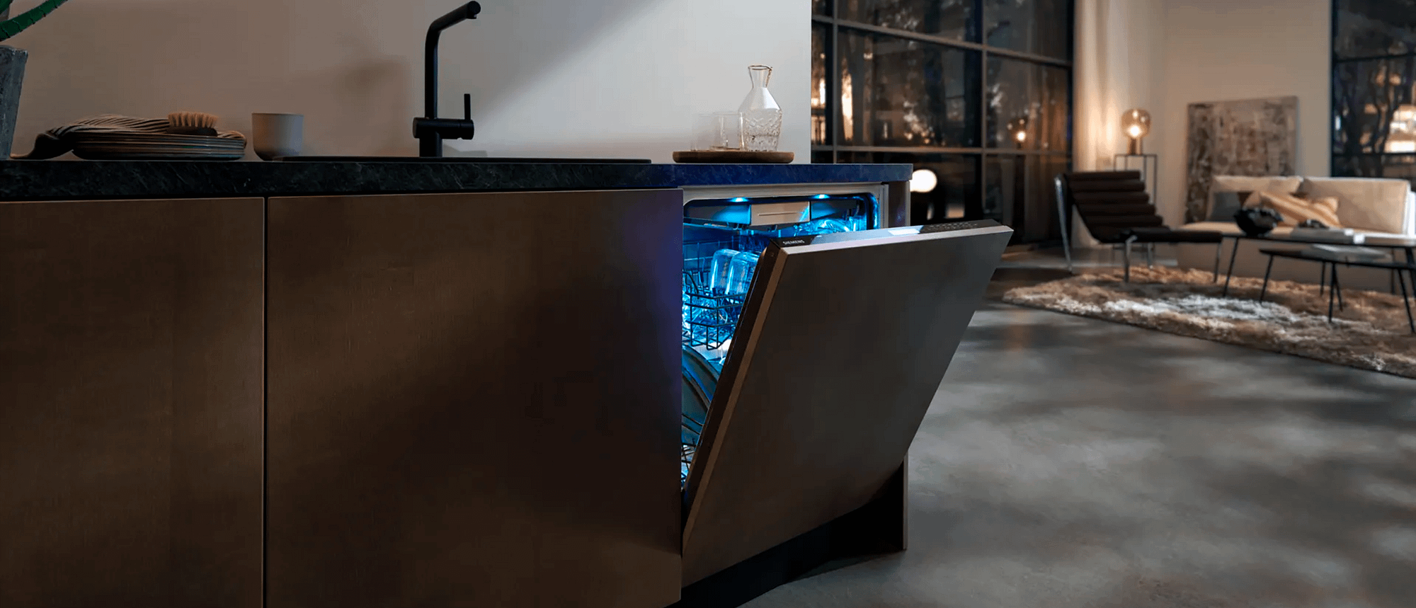 Kitchen with dimmed down lights, with a slighlty opened dishwasher emitted a blue light.