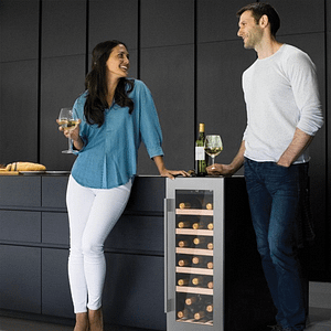 Man and woman leaning on a freestanding wine cooler