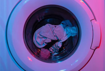 Close up of washing machine showing clothes on a wash cycle