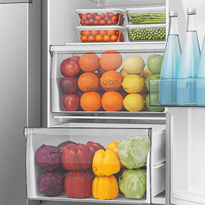 Inside view of fridge that has vegetables aligned in rainbow order.