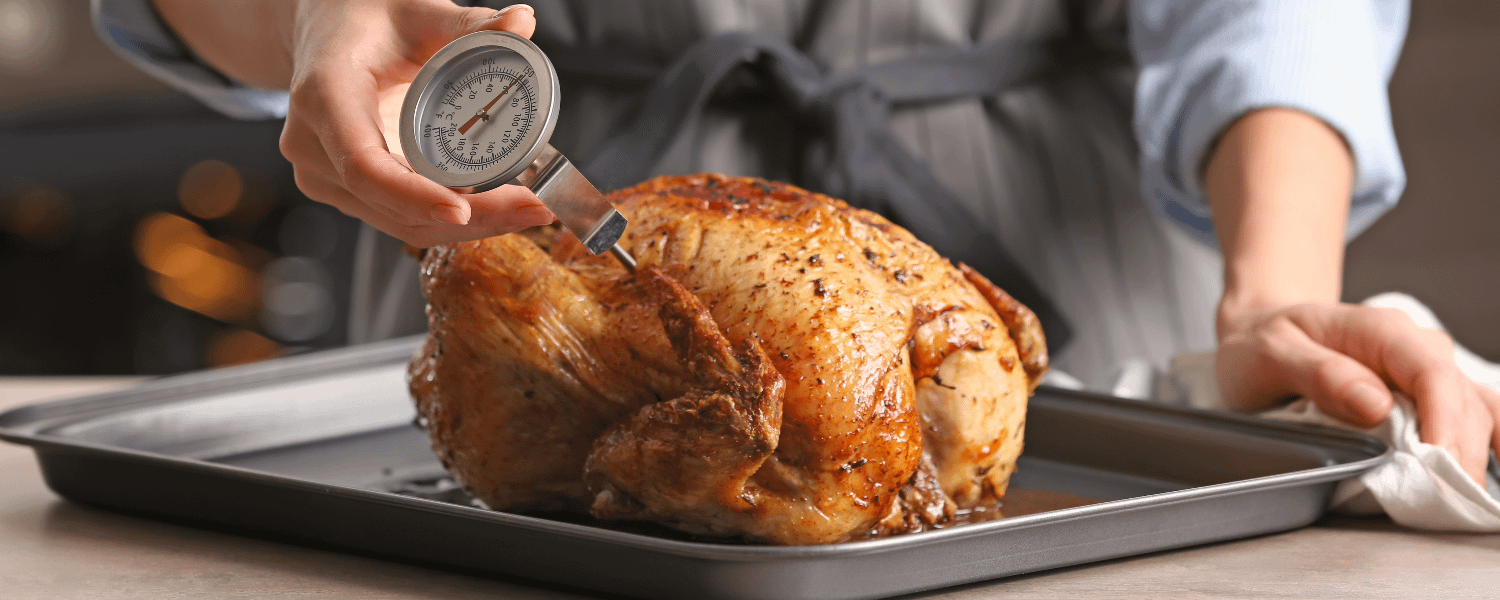 Measuring the temperature of a roast chicken with a meat thermometer