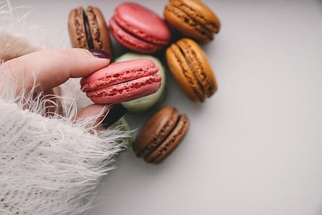 variety of macrons with a woman holding one