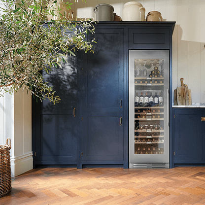 Large wine cooler integrated into dark blue cabinets