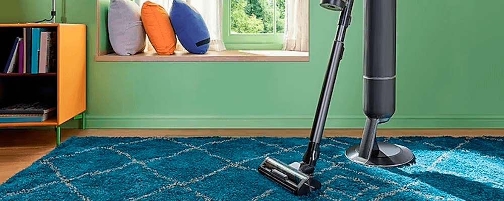 Samsung vacuum cleaner in a room with green walls and a fluffy blue rug.