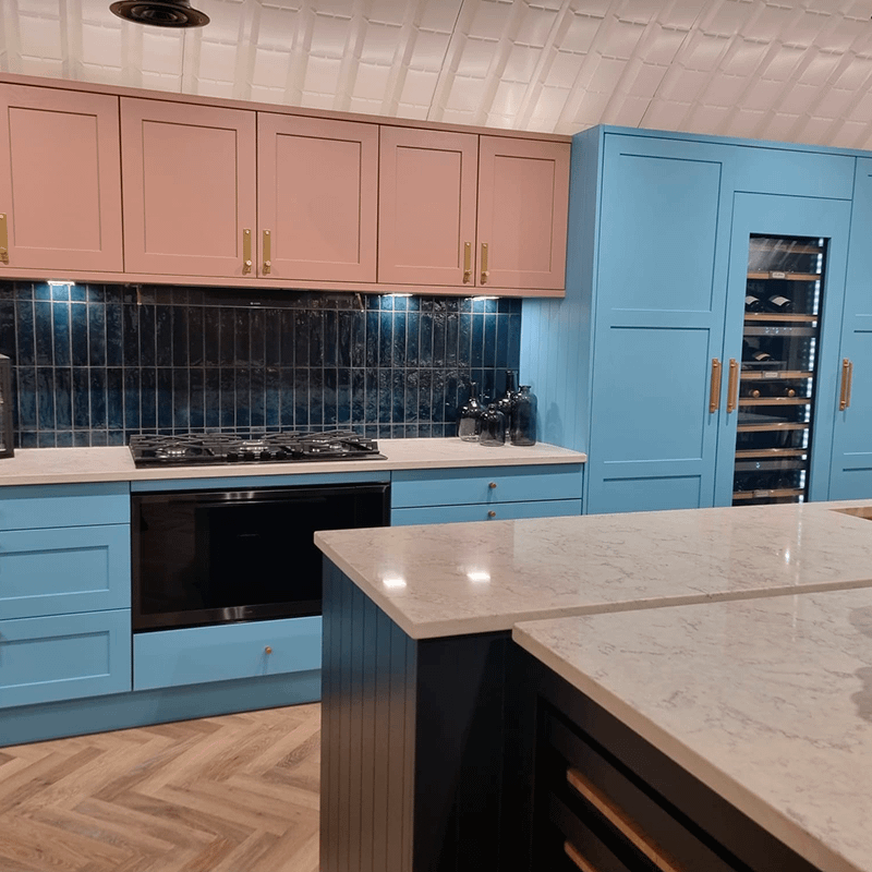 Kitchen display with blue lower cabinets and pink upper cabinets