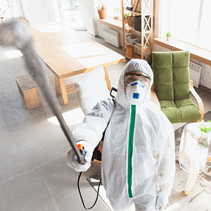 Person in biohazard suit cleaning mould on ceiling