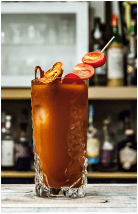 A Bloody Mary cocktail with tomatoes on a cocktail stick to garnish