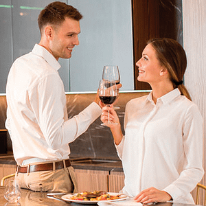 Man and woman enjoying glasses of wine in kitchen