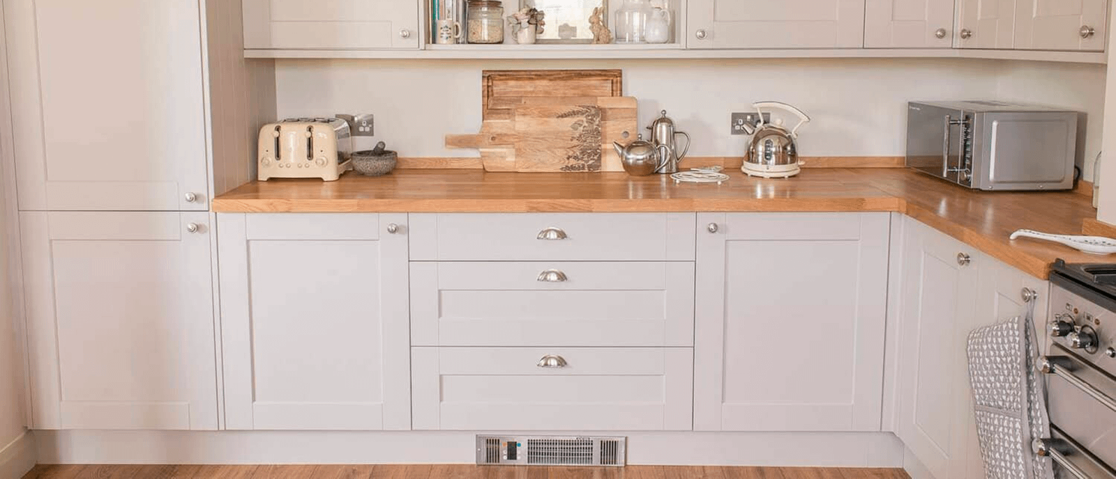 White kitchen cabinets with a plinth heater