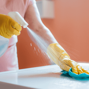 Spraying kitchen cleaning product onto white surface