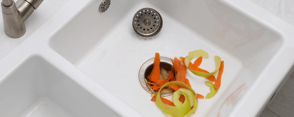 Peeled vegetables in a sink with a waste disposal unit