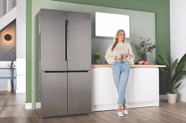 Woman standing next to Bosch American style fridge freezer