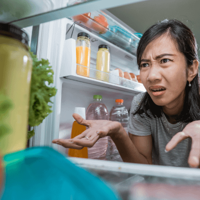 Person looking into a fridge, looking confused. Perspective from within the fridge.