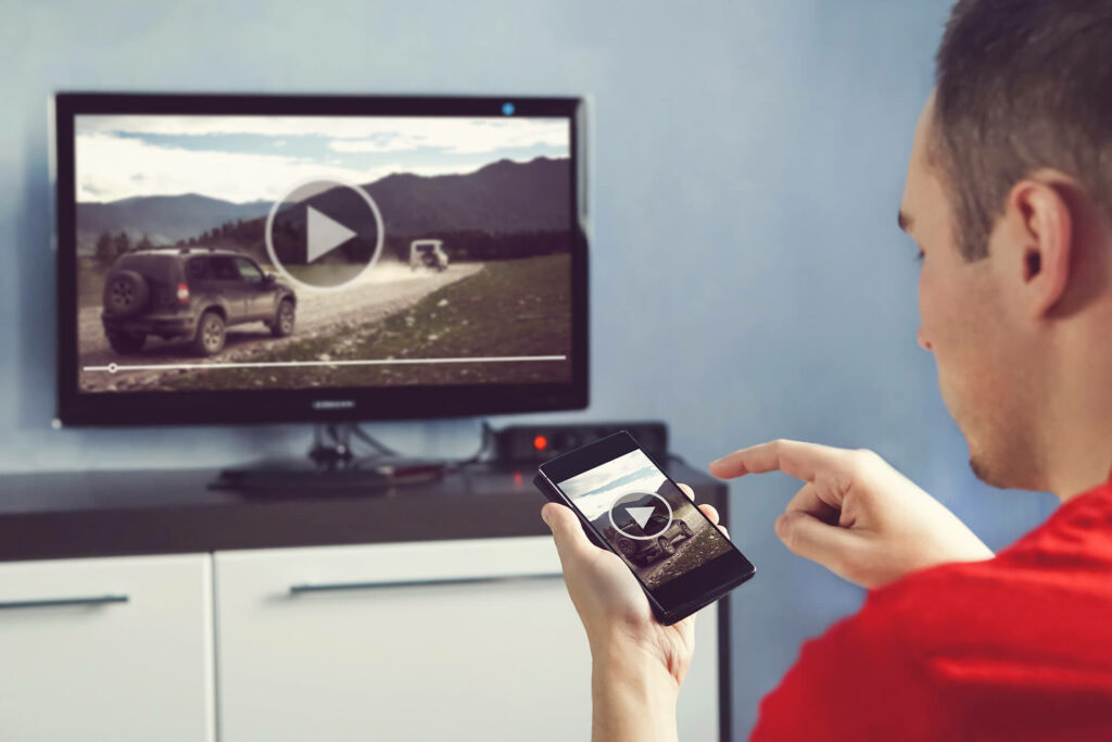 A man casting a video from his phone to his smart TV