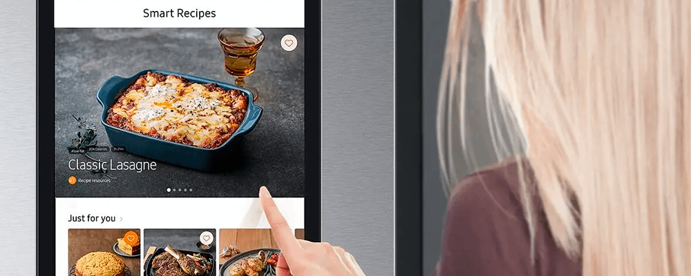 Blonde woman looking at Samsung Family Hub screen of Smart Recipes