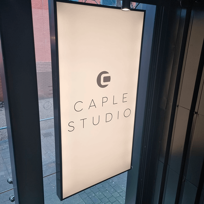 A white sign on a windowed door reading "Caple Studio"