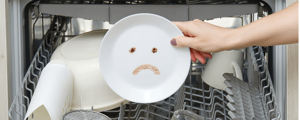 Handing taking a plate with a sad face out of a dishwasher