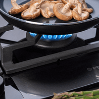 Frying pan with mushrooms cooking on a Caple C889G 88cm 5 Burner Gas On Glass Hob