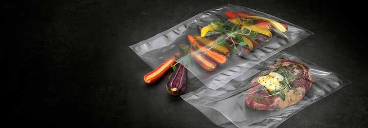 Vegetables and steak in separate vacuum seal bags ready for sous vide cooking.