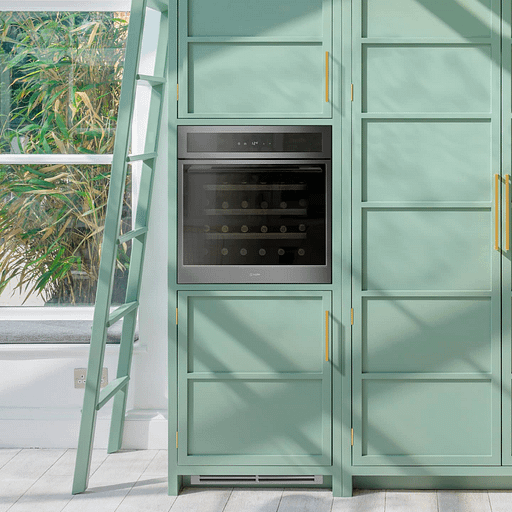 A wine cooler built into green cabinetry, with a ladder leaning against the cabinets on the left.