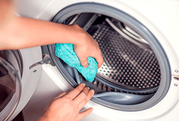 A sponge cleaning the inside seal of a washing machine