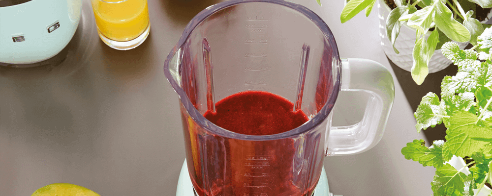 Top of blender with red smoothie inside