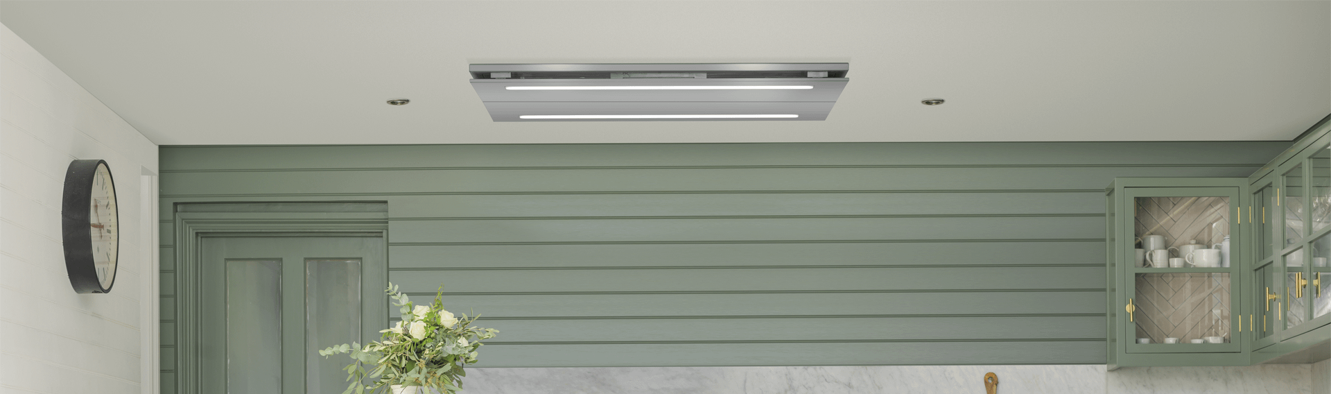 A Caple cieling hood with a green wall paper and clock on the left of the picture