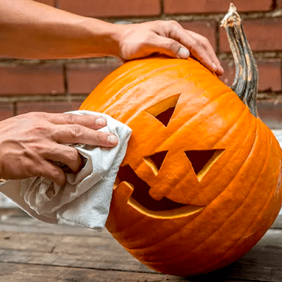 Wiping down a jack o' lantern pumpkin