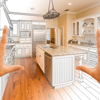 Person holding up index fingers and thumbs to a sketch of a kitchen that is transforming into real life