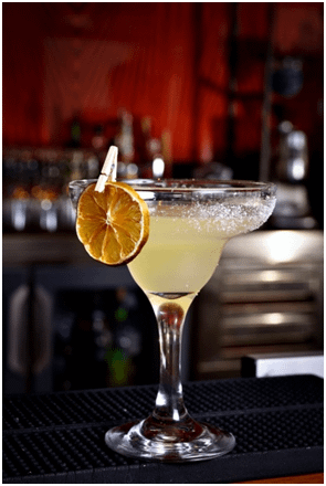 A Margarita cocktail with a dried orange garnish