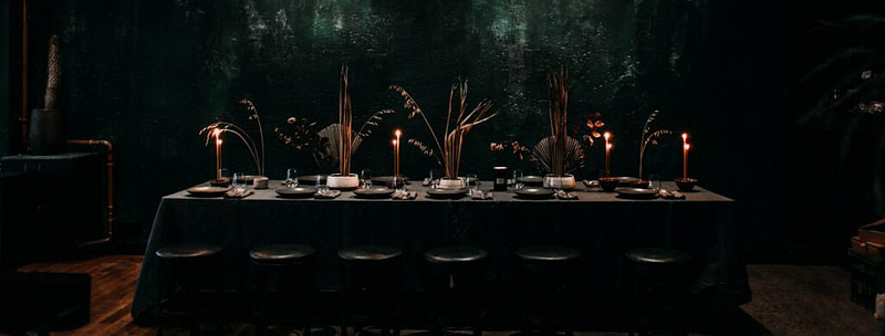 A dinner party table set for a spooky murder mystery dinner party