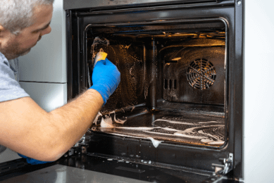 Man scrubbing inside of oven
