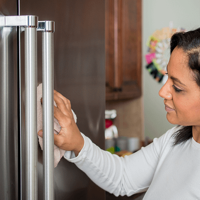 Wiping stainless steel fridge freezer with microfiber cloth