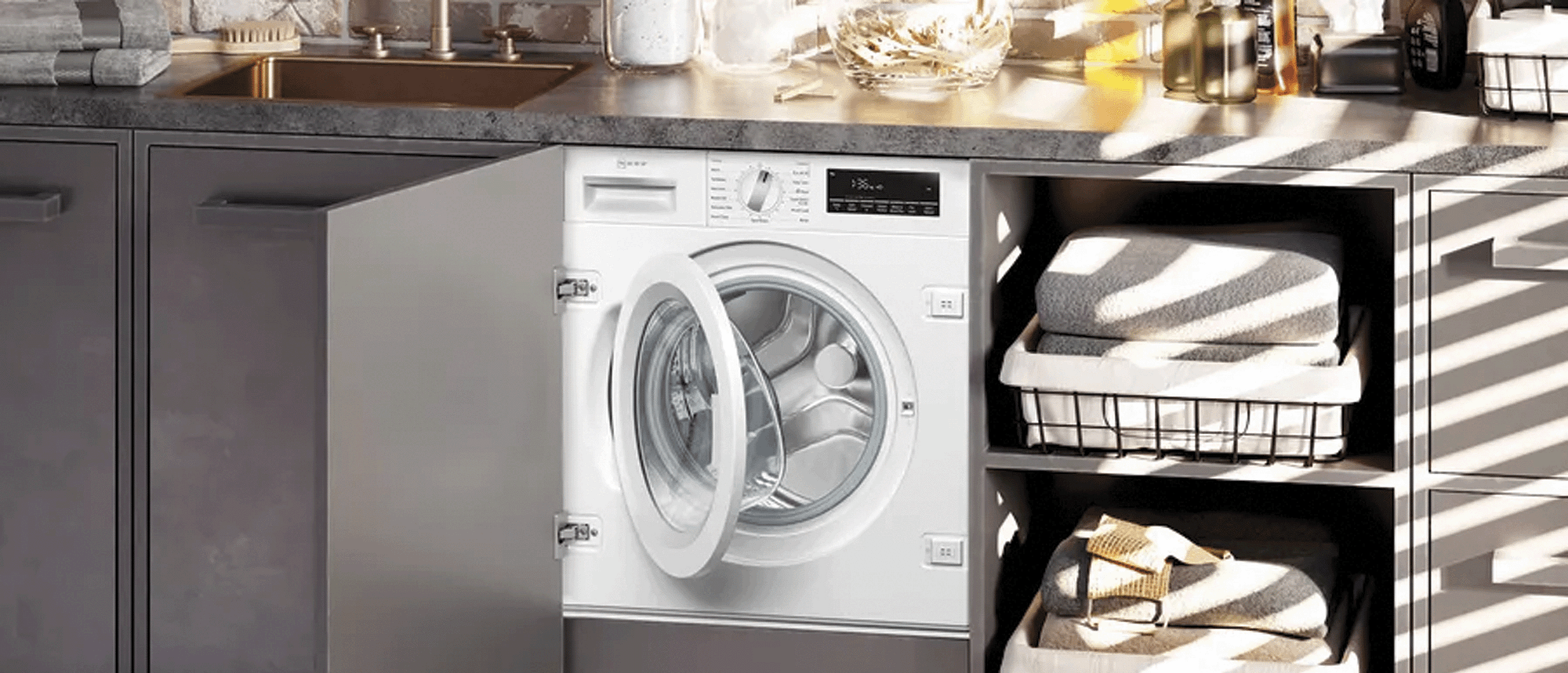 White Neff built-in washing machine with open door. Shelves are built in next to it with towels.