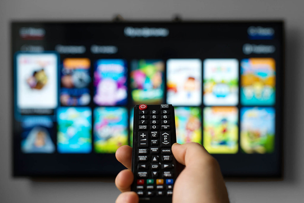 A person using a remote control on a smart TV