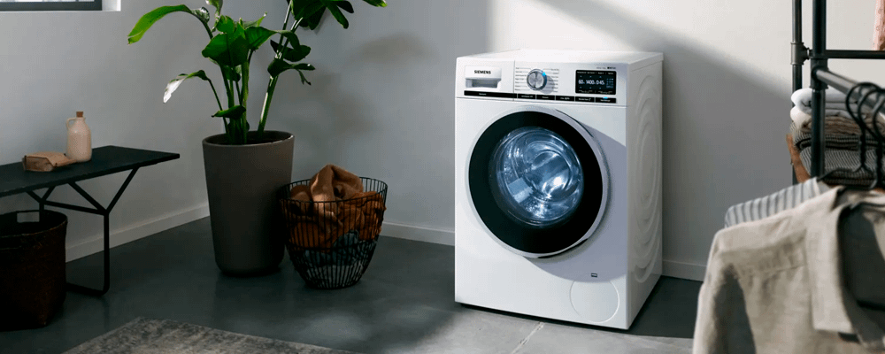 Siemens washing machine in room with plant and laundry storage