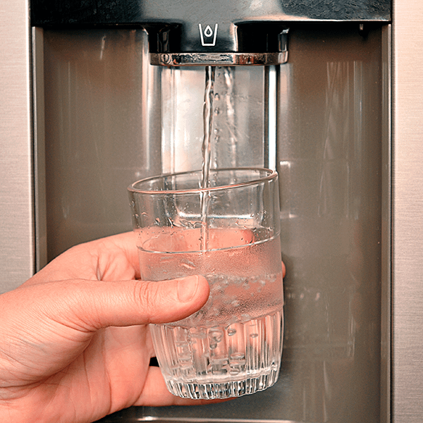 Filled glass with water from a fridge water dispenser