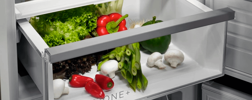 An interior snippet of an AEG fridge, shown with fresh vegetables inside of a drawer.