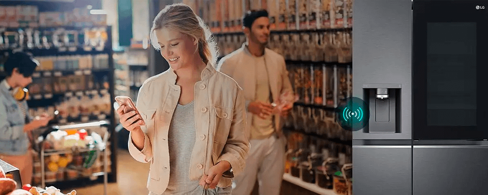 Woman using app to connect to her LG Thinq Fridge Freezer to check stock whilst shopping.