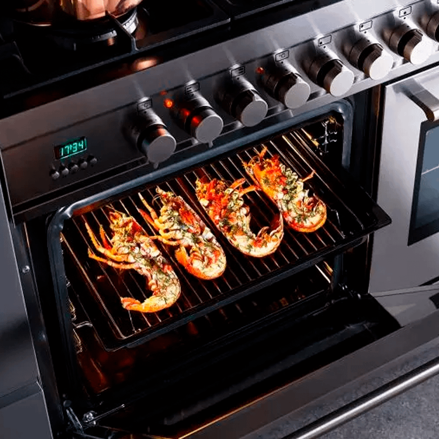 Close up of an open oven door on a range cooker. A grill tray with frilled shrimp shows.