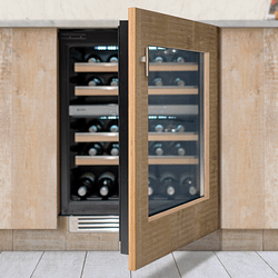 An integrated Caple wine cooler built into a light wood cabinet