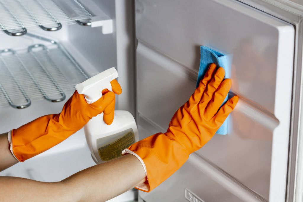 Person cleaning the inside of a freezer