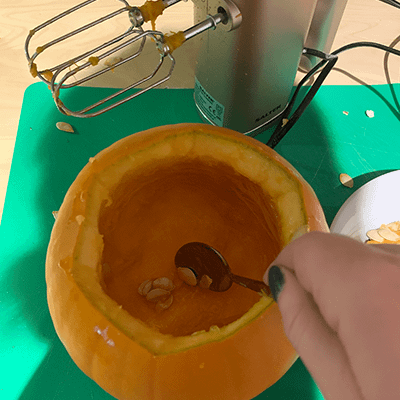 Using a hand mixer, or hand whisk, to clean out a pumpkin