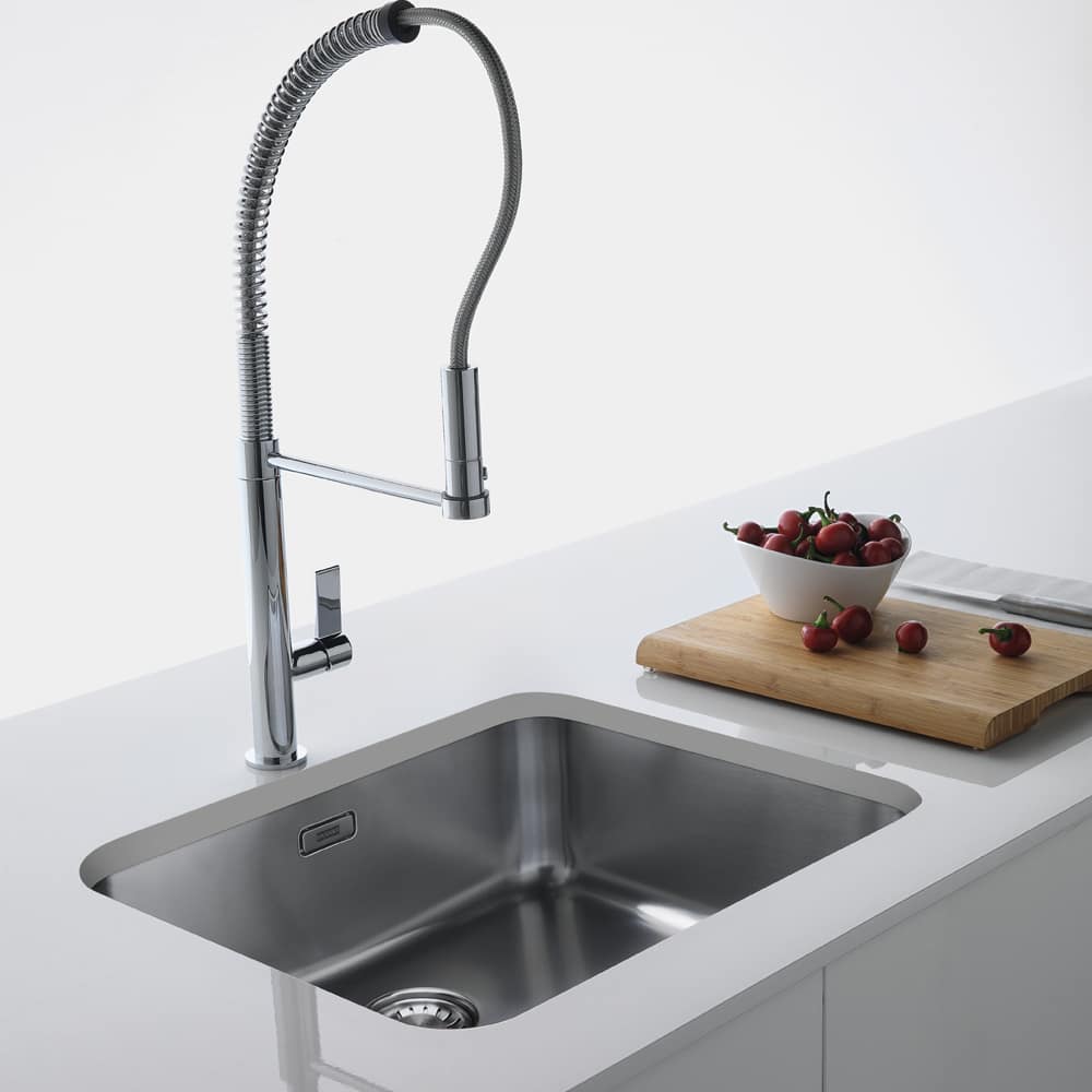 franke-lax110-50-41-1000x1000 A Franke Largo sink finished in stainless steel. The undermount sink is fitted into a white worktop and there is a wooden chopping board with vegetables on it next to the sink.