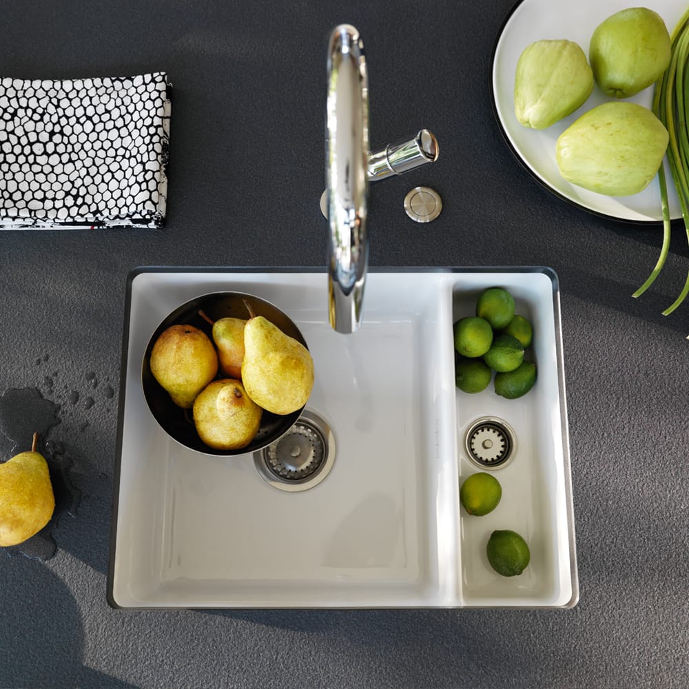 kubus160-v2-1000x1000 Franke Kubus 160 undermount sink in ceramic white. Bowls of lemons and limes are inside the sink as well as on the grey worktop.