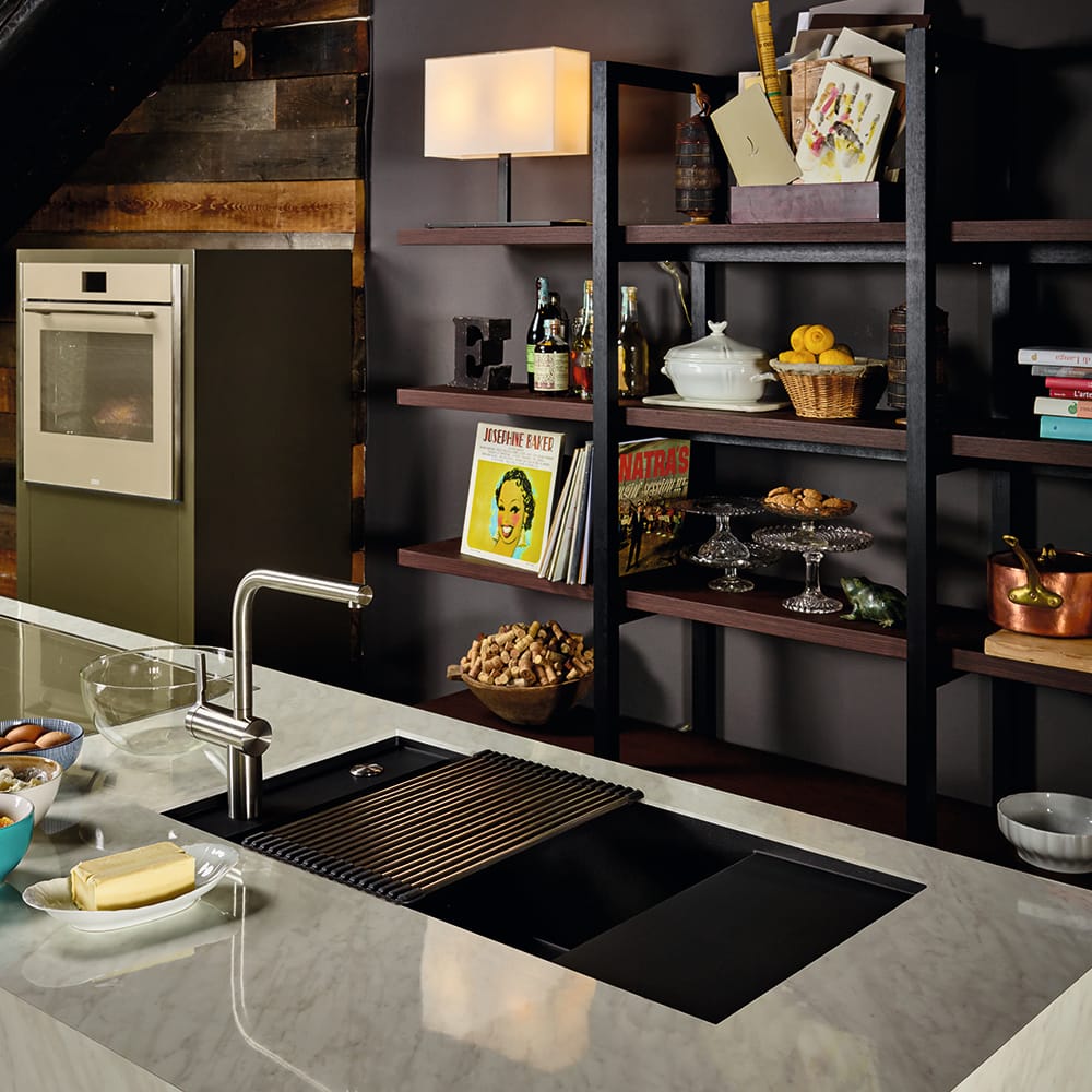 franke-FSG111-2-1000x1000 Franke Fresno undermount sink in matt black. In a dark kitchen room set with a light grey worktop. Surrounded by books and colourful decor