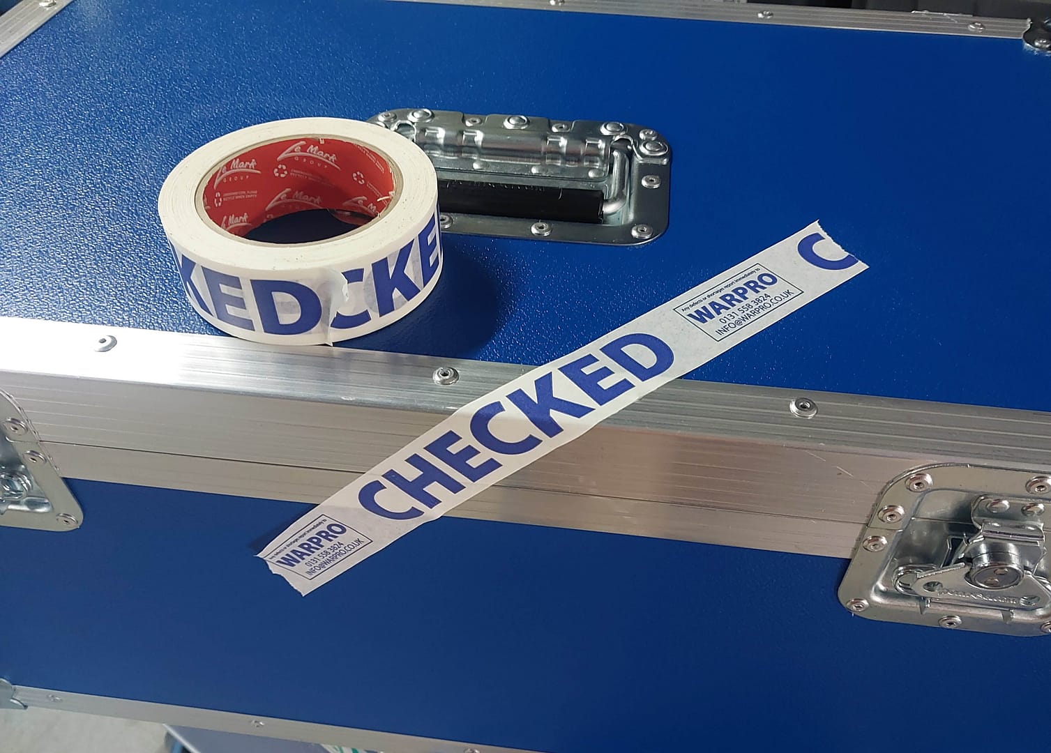 Le Mark custom printed paper tape marked “CHECKED” applied to flight cases and cable reels for War Productions
